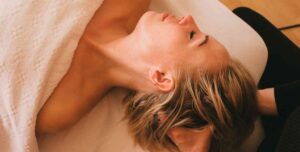 kvinde får afslappende hovedbundsmassage under ansigtsbehandling