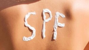 kvindes ryg med ordet SPF skrevet i solcreme