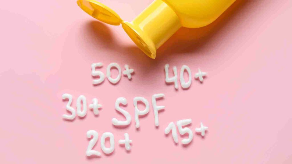 lyserød baggrund med gul solcreme flaske samt tallene 15, 20, 30, 50, 50 og ordet SPF skrevet i solcreme
