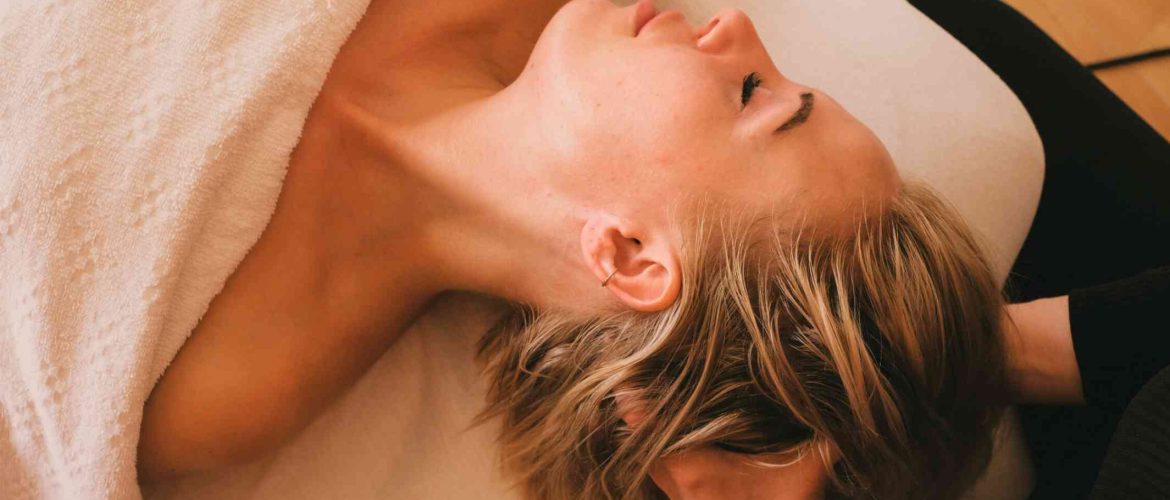 kvinde får afslappende hovedbundsmassage under ansigtsbehandling
